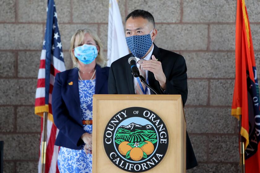 Dr. Clayton Chau, right, director of the OC Health Care Agency, and Orange County 2nd District Supervisor Katrina Foley, left, answers questions during the opening of a new COVID-19 vaccination super POD site at the Orange County fairgrounds in Costa Mesa on Wednesday.