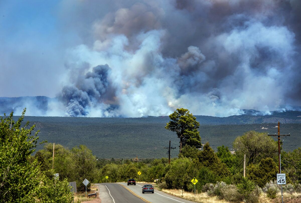 Smoke rises from mountains where a fire is burning vegetation