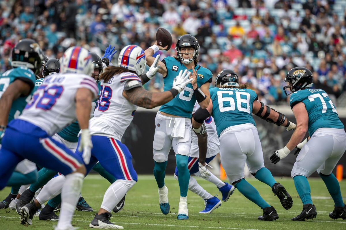 Jacksonville Jaguars quarterback Trevor Lawrence (16) throws over the Buffalo Bills defense.