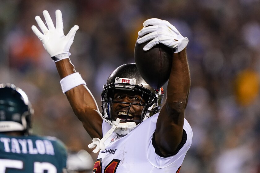 Tampa Bay Buccaneers receiver Antonio Brown lifts his arms and smiles during a game against the Eagles.