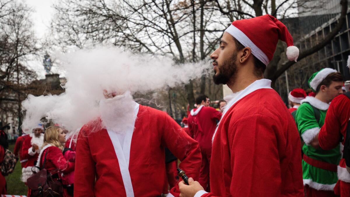 A reveller dressed in a Father Christmas costume smokes from an electronic cigarette on December 10.