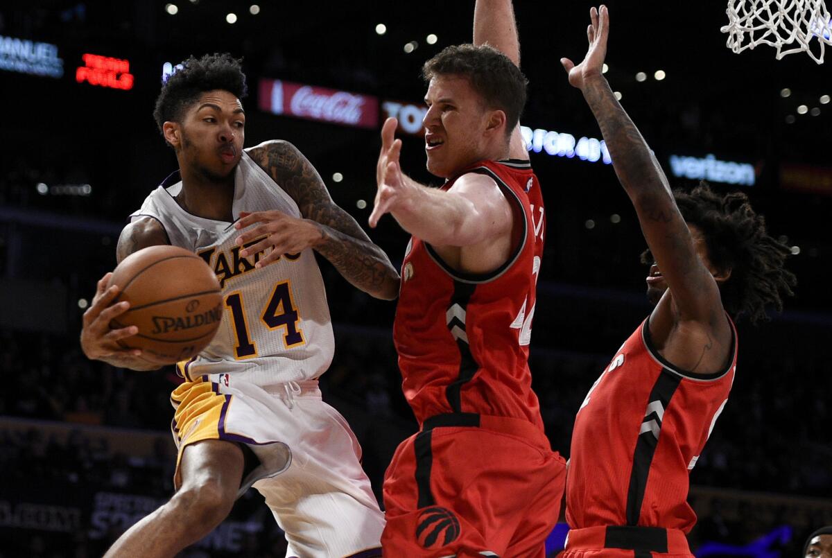 Lakers forward Brandon Ingram, left, tries to pass around Toronto center Jakob Poeltl on Jan. 1.