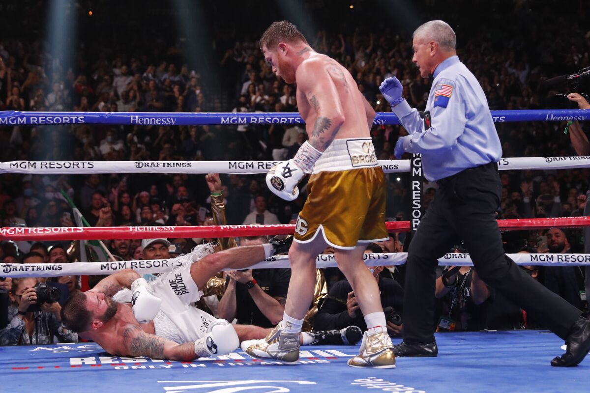 Canelo Álvarez knocks down Caleb Plant during the 11th round of their super middleweight title fight Saturday.