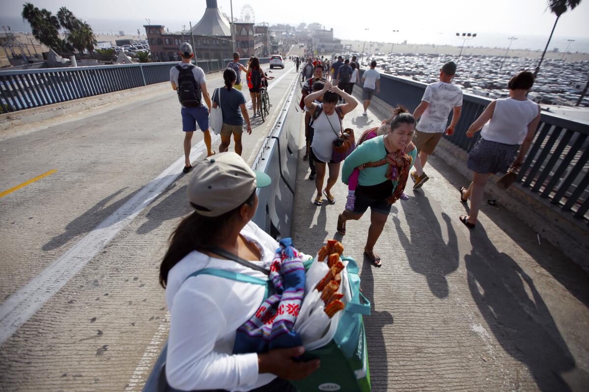 A street vendor sells churros out of a Whole Foods bag at the Santa Monica Pier last year.