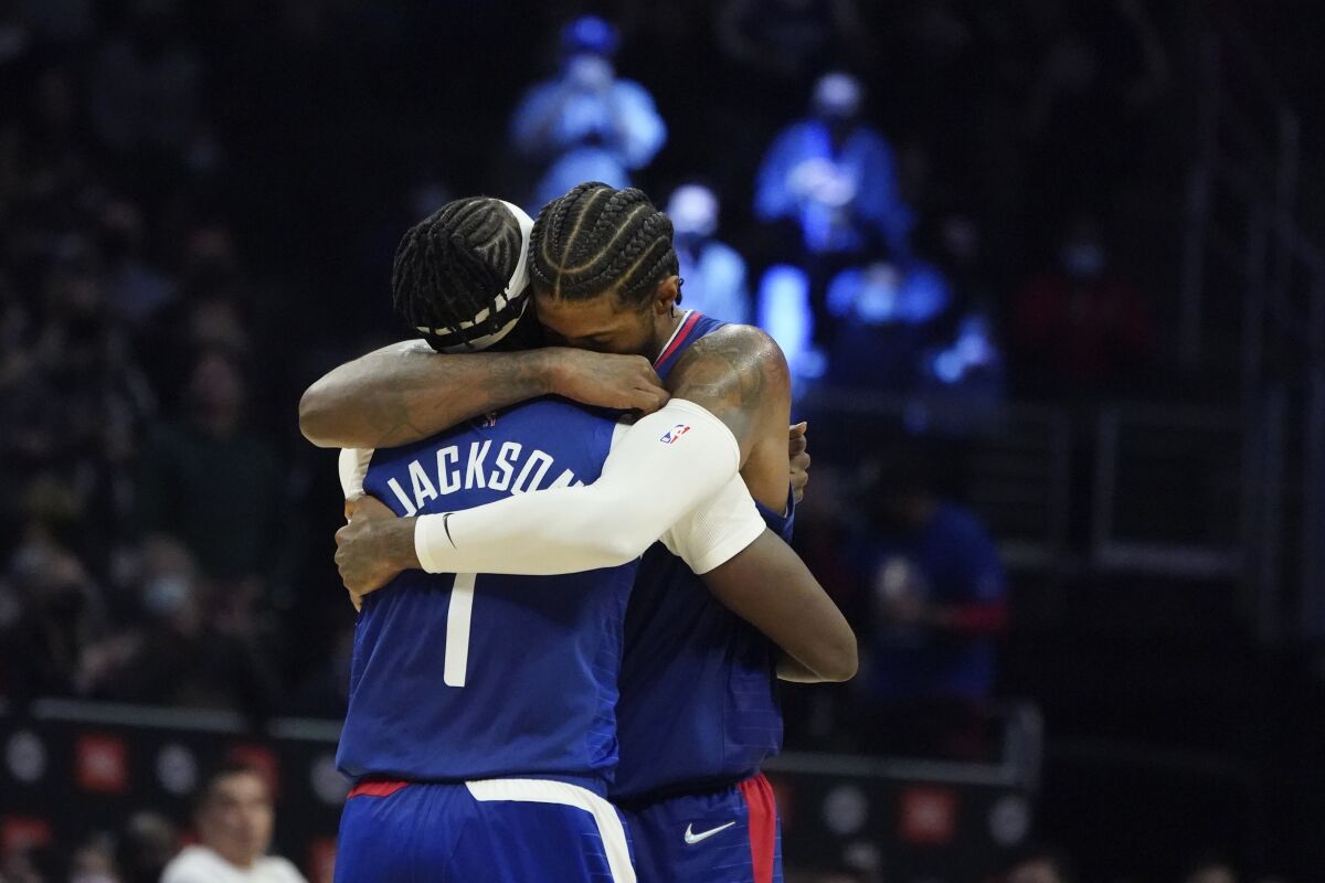Clippers guard Reggie Jackson (1) gets a hug from teammate Paul George 