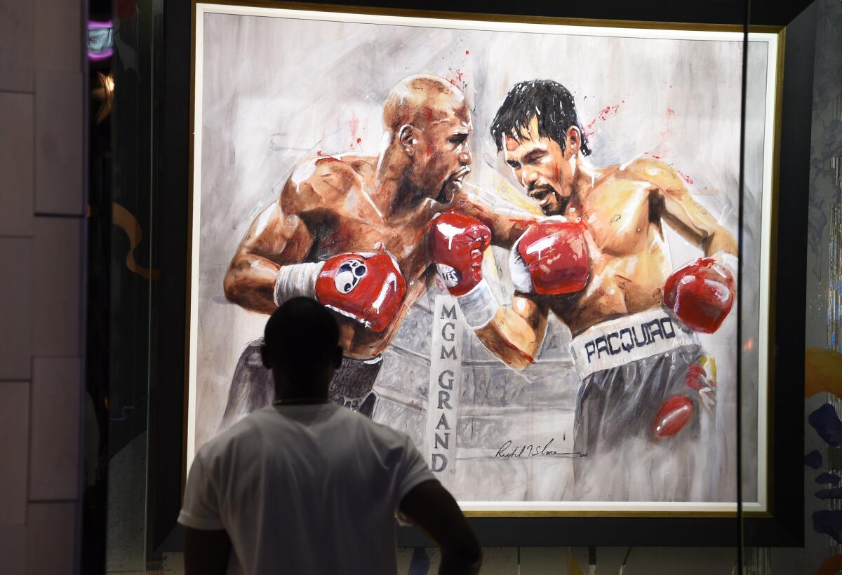 Floyd Mayweather Jr. and Manny Pacquaio clash in "The Superfight" by artist Richard Slone at a gallery at the MGM Grand Hotel in Las Vegas, where the two boxers were set to clash Saturday night.