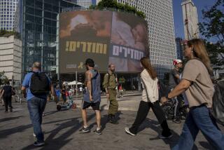 People pass by a sign calling for the release of hostages held in the Gaza Strip by Hamas for nearly a year, in Tel Aviv, Israel, Monday, Sept. 10, 2024. (AP Photo/Ohad Zwigenberg)