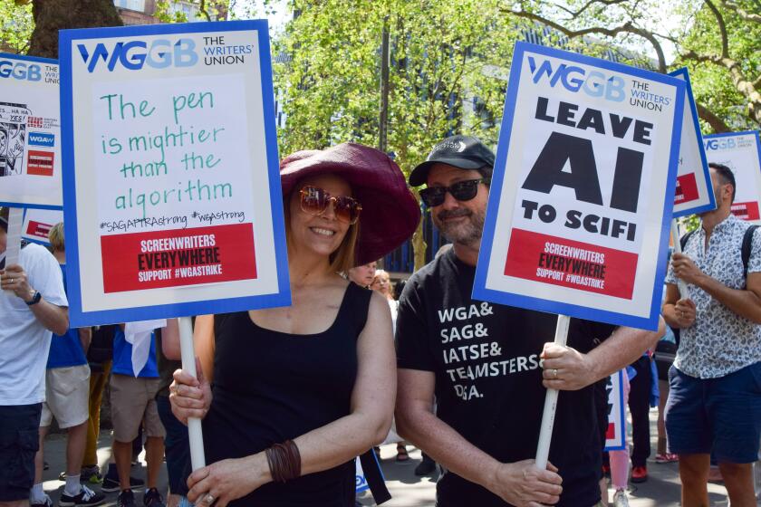 LONDON, UNITED KINGDOM - 2023/06/14: Protesters hold placards in support of writers and opposed to Artificial Intelligence (AI) replacing writers, during the demonstration. UK screenwriters and Writers' Guild Of Great Britain (WGGB) members staged a rally in Leicester Square in solidarity with striking screenwriters in the USA. (Photo by Vuk Valcic/SOPA Images/LightRocket via Getty Images)