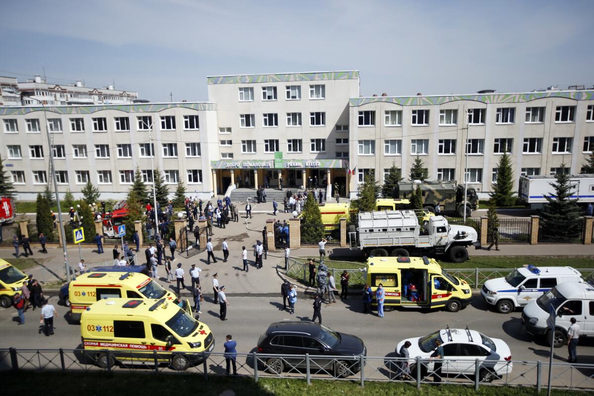 Ambulances and police cars are parked at a school after the shooting in Kazan, Russia