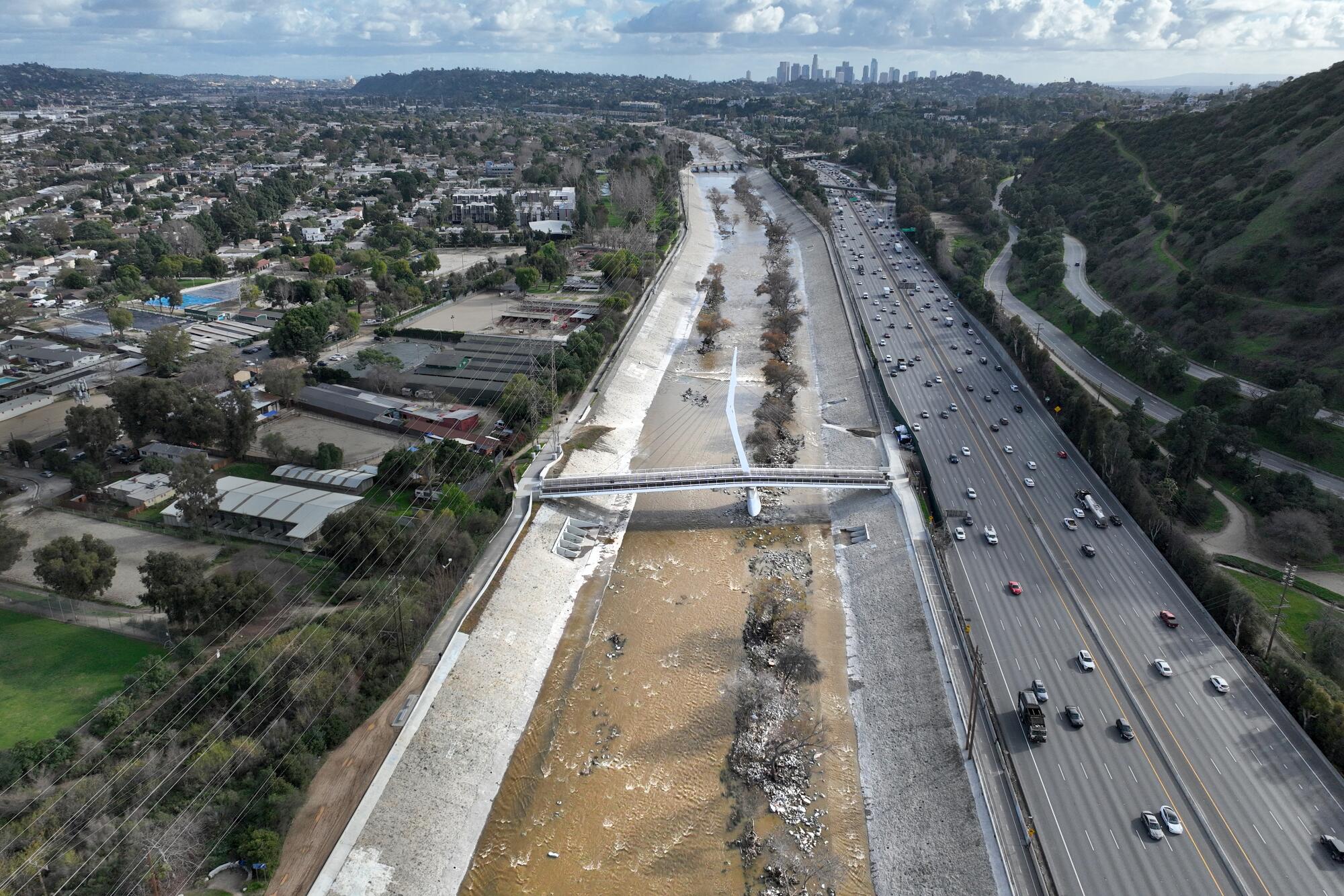 After heavy rains, water flows down the concrete-lined Los Angeles River. 