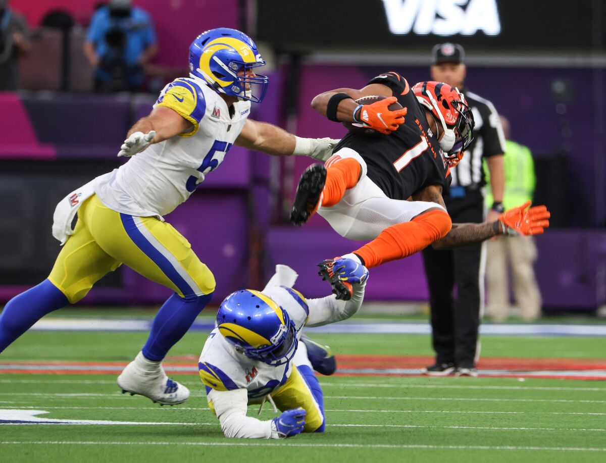 Cincinnati Bengals wide receiver Ja'Marr Chase, top, is tacked during the first half.