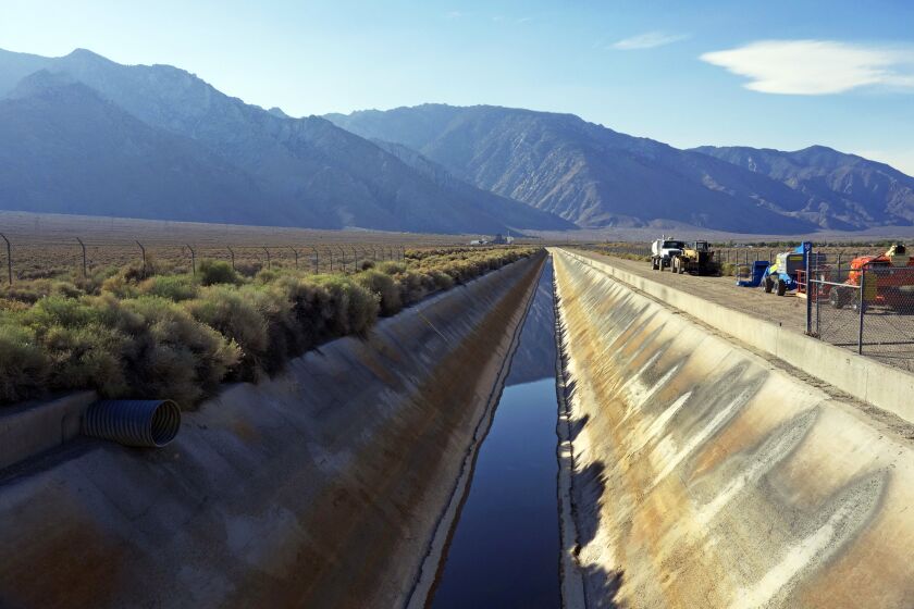 In this Aug. 23, 2015, photo, the Los Angeles Aqueduct has reduced water flow near the eastern Sierra town of Olancha, Calif., after the aqueduct was partially dammed upstream of this area this summer. On Tuesday, Oct. 27, 2015, because of the ongoing drought, water was again flowing south in greater quantities as workers removed the earthen dam that had diverted runoff to the parched Owens Valley. (AP Photo/Brian Melley)