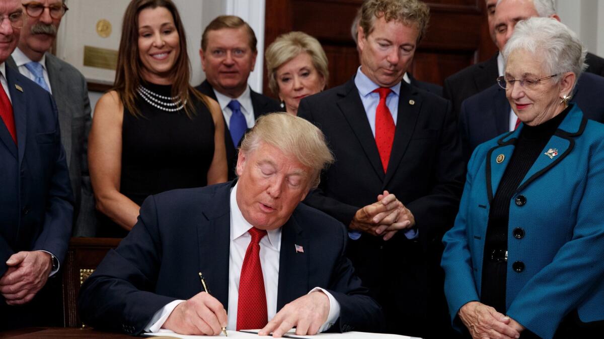 President Trump signs an executive order undermining the Affordable Care Act in the Oval Office, on Oct. 12.