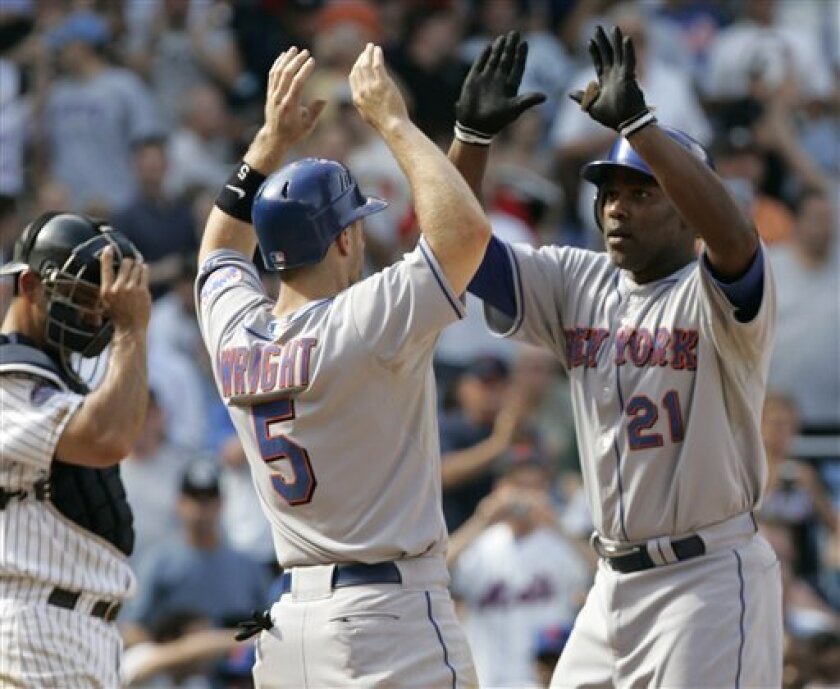 New York Mets' Carlos Delgado (21) celebrates with teammate David Wright (5) after hitting a grand slam home run during the sixth inning of an interleague baseball game as New York Yankees catcher Jorge Posada, left, looks on Friday, June 27, 2008 in New York. (AP Photo/Frank Franklin II)