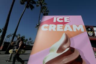 LOS ANGELES, CALIF. - NOV. 10, 2021. Beachgoers walk past a sign advertising soft serve ice cream along the boardwalk in Venice Beach on Wednesday, Nov. 10, 2021. Warmer weather is expected in coming days, with temperatures in some parts of Southern California reaching into the 90s. (Luis Sinco / Los Angeles Times)