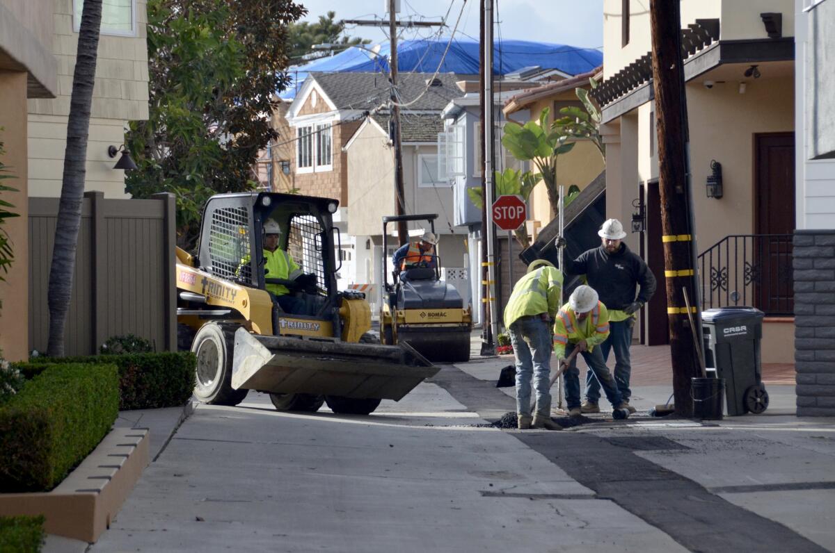Underground utility crew completes patches over trenches in a narrow alley along the North Bayfront of Balboa Island.
