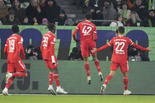 Jamal Musiala (2do de derecha a izquierda) festeja con sus compañeros del Bayern Múnich, tras anotar un tanto ante Wolfsburgo, el domingo 5 de febrero de 2023 (AP Foto/Michael Sohn)