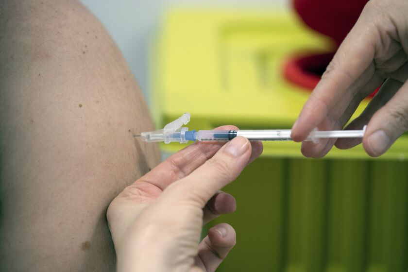 Un empleado del hospital universitario administra la vacuna de Moderna contra el COVID-19 a un paciente en Düsseldorf, Alemania, el lunes 18 de enero de 2021. (Federico Gambarini/dpa vía AP)