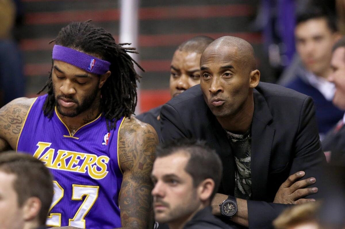 Kobe Bryant sits on the bench next to Jordan Hill during a game against the Phoenix Suns.