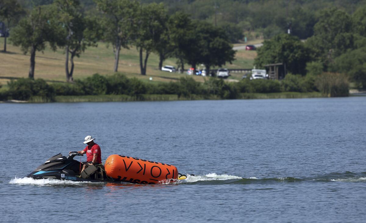 A jet ski pulls in buoys from the CrossFit Games at Marine Creek Lake