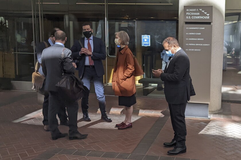 Former Theranos executive Ramesh "Sunny" Balwani, right, stands near his legal team outside Robert F. Peckham U.S. Courthouse in San Jose, Calif., on March 1, 2022. Balwani, the jilted lover and business partner of former Theranos CEO Elizabeth Holmes, finally has his chance to defend himself against charges that he was Holmes' accomplice in a Silicon Valley scam involving a ballyhooed blood-testing technology that flopped. Opening statements in his trial are scheduled Wednesday, March 16, 2022 in the same San Jose, Calif. courtroom where a jury found Holmes guilty of investor fraud and conspiracy in January. (AP Photo/Michael Liedtke)