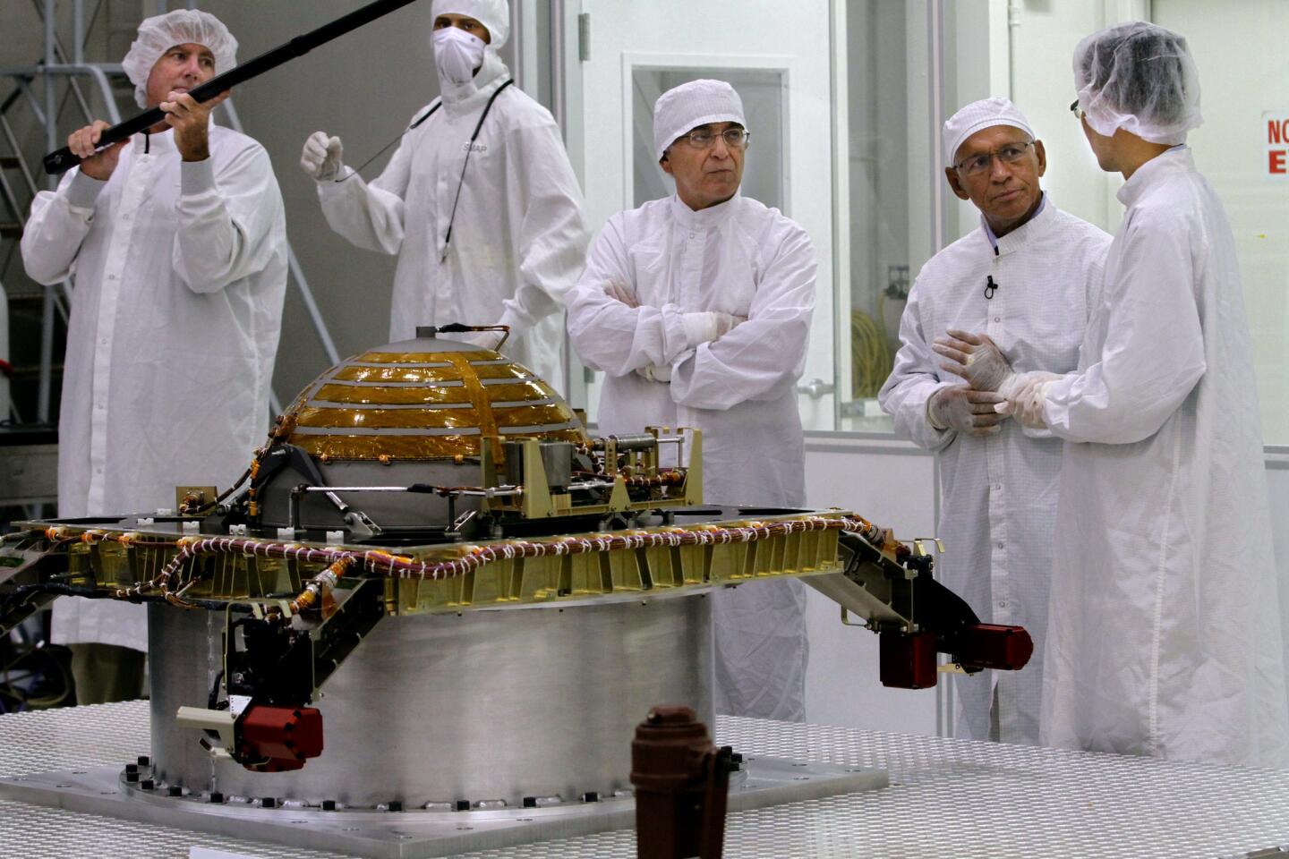 NASA Administrator Charles Bolden, second from right, speaks with SMAP spacecraft lead systems engineer Wayne Lee, right, during visit to the Spacecraft Assembly Facility Cleanroom at the Jet Propulsion Laboratory on Tuesday, August 13, 2013. The SMAP propulsion module is in front of them. The Soil Moisture Active Passive (SMAP) is a NASA Earth satellite mission that will map Earth's land-surface soil moisture.