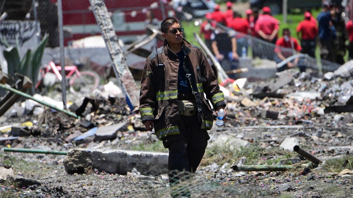 A firefighter walks amid the destruction after explosions tore through several fireworks factories in Tultepec, Mexico, on July 5, 2018.