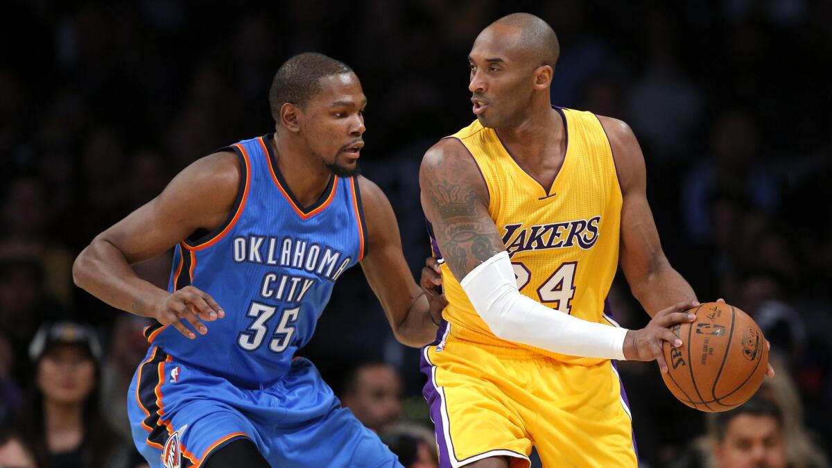 Lakers guard Kobe Bryant protects the ball from Oklahoma City Thunder forward Kevin Durant during a game at Staples Center on Dec. 23, 2015.