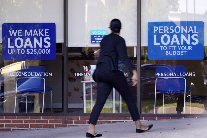 Una mujer pasa frente a una oficina que ofrece préstamos personales en Franklin, Tennessee, el 1ro de octubre del 2020. (AP Photo/Mark Humphrey, File)