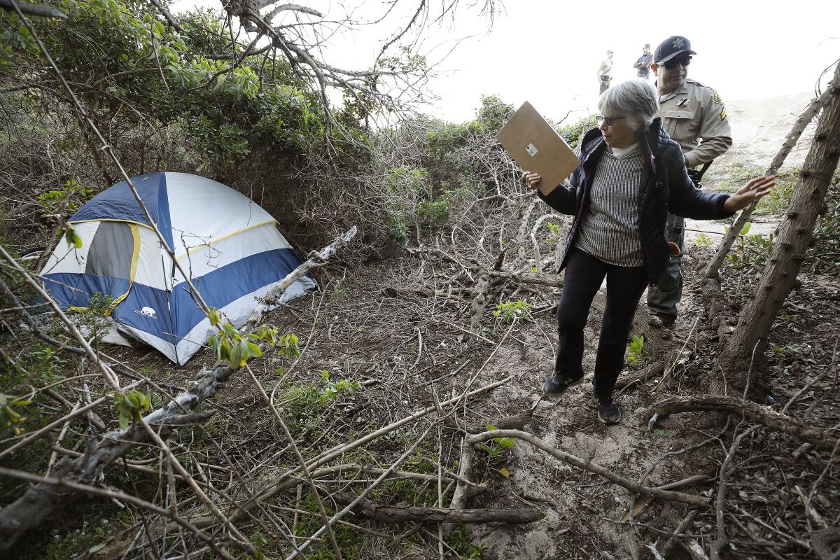 Volunteer Kay Gabbard and Deputy Santiago Cienfuegos look for signs of homeless people in Malibu.