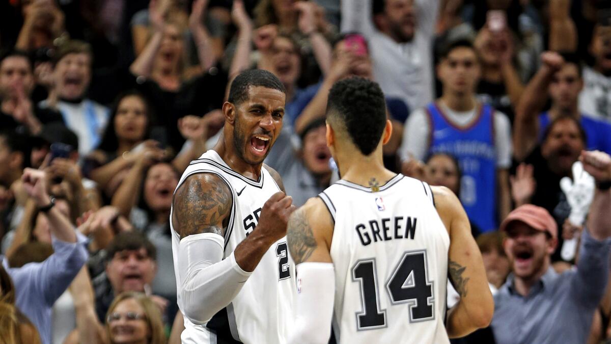 Spurs forward LaMarcus Aldridge celebrates with teammate Danny Green after defeating the Thunder on Friday night.
