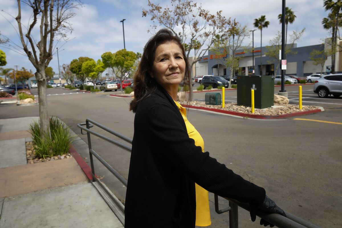Maria Esperanza Gonzalez stands at the edge fo the parking lot in City Heights where she use to live in an apartment building but was clears to make way for a large grocery store and several other smaller retail stores.
