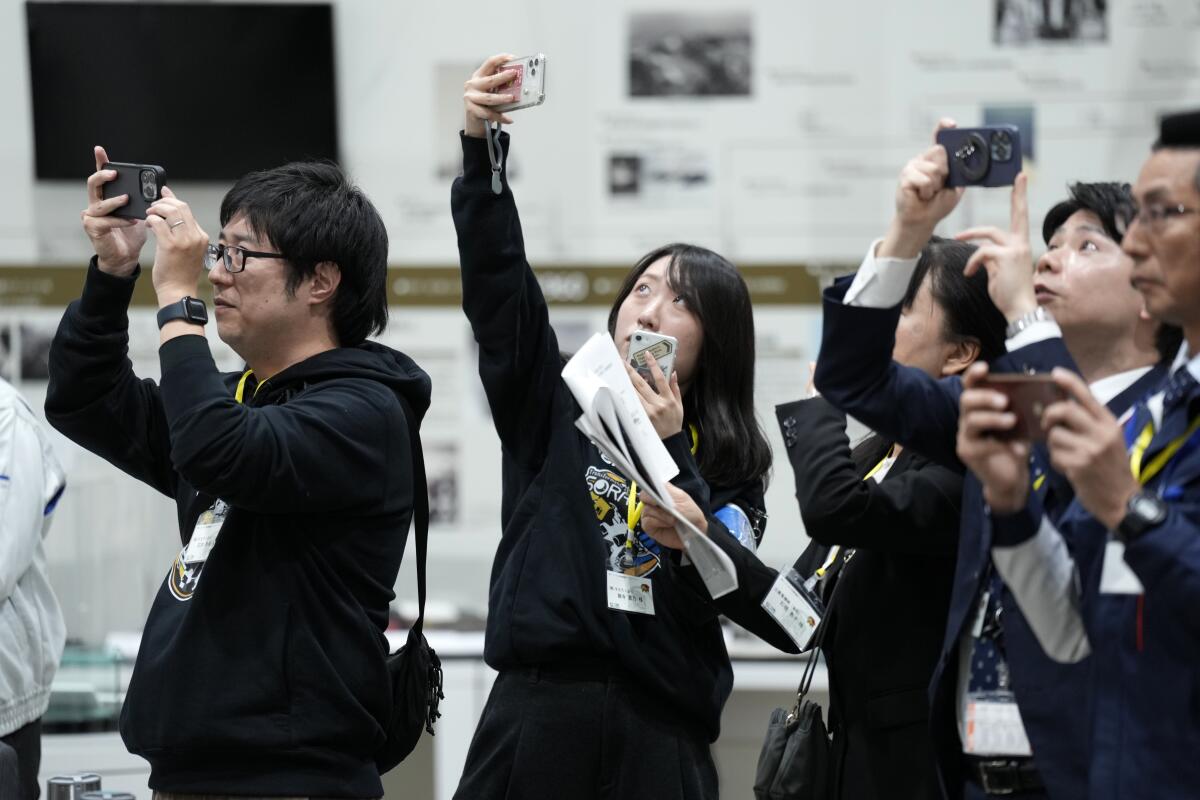 People hold cameras while watching a livestream event 