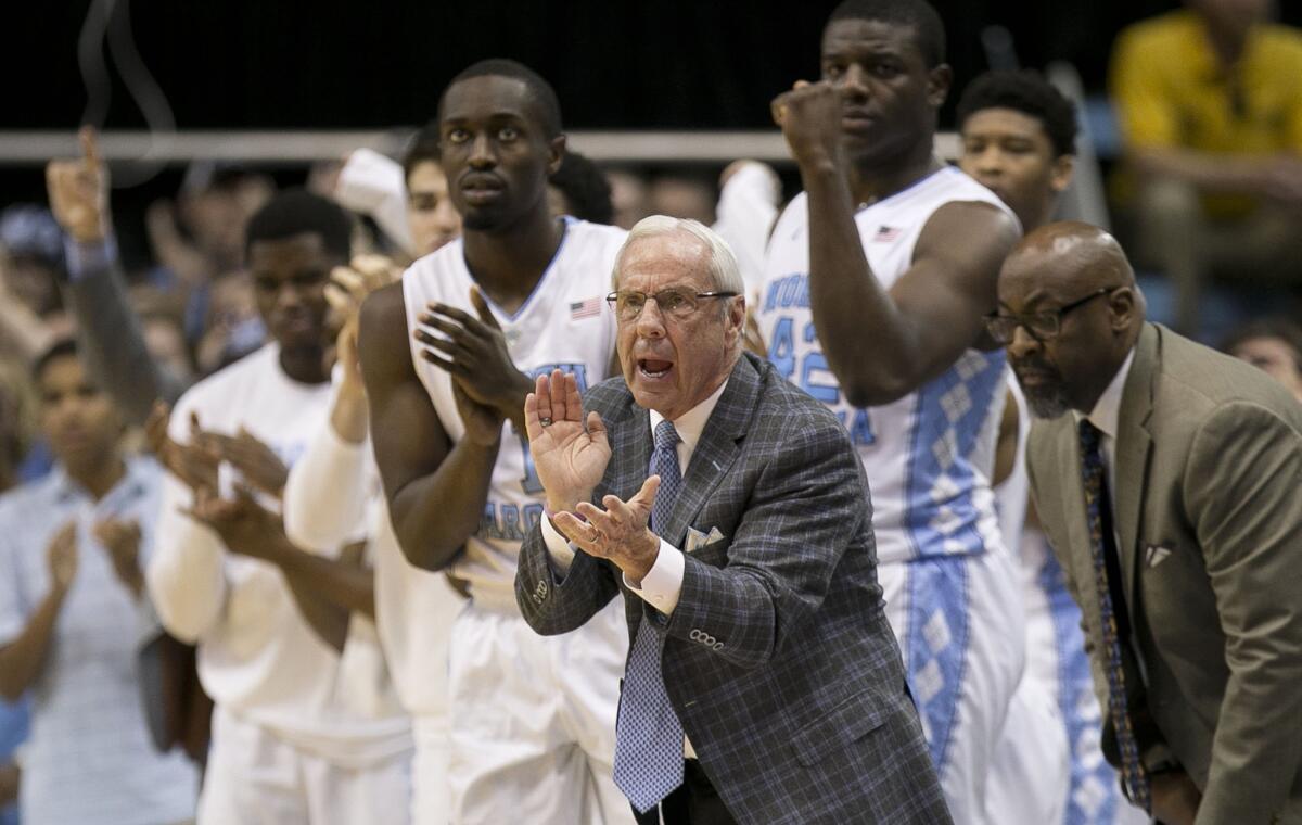 North Carolina Coach Roy Williams, center, applauds his team's performance during the first half.