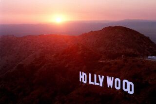 FILE- This June 30, 1999 file photo shows the sun setting behind mountains as the Hollywood sign overlooks Los Angeles. For a century and a half California has been a destination for every conceivable sort of adventurer. (AP Photo/Reed Saxon, File)