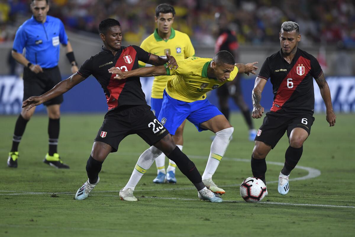 LOS ANGELES, CALIFORNIA - SEPTEMBER 10: Richarlison #9 of Brazil handles the ball defended by Pedro Aquino #23 of Peru in the 2019 International Champions Cup match on September 10, 2019 at Los Angeles Memorial Stadium in Los Angeles, California. (Photo by Kevork Djansezian/Getty Images) ** OUTS - ELSENT, FPG, CM - OUTS * NM, PH, VA if sourced by CT, LA or MoD **