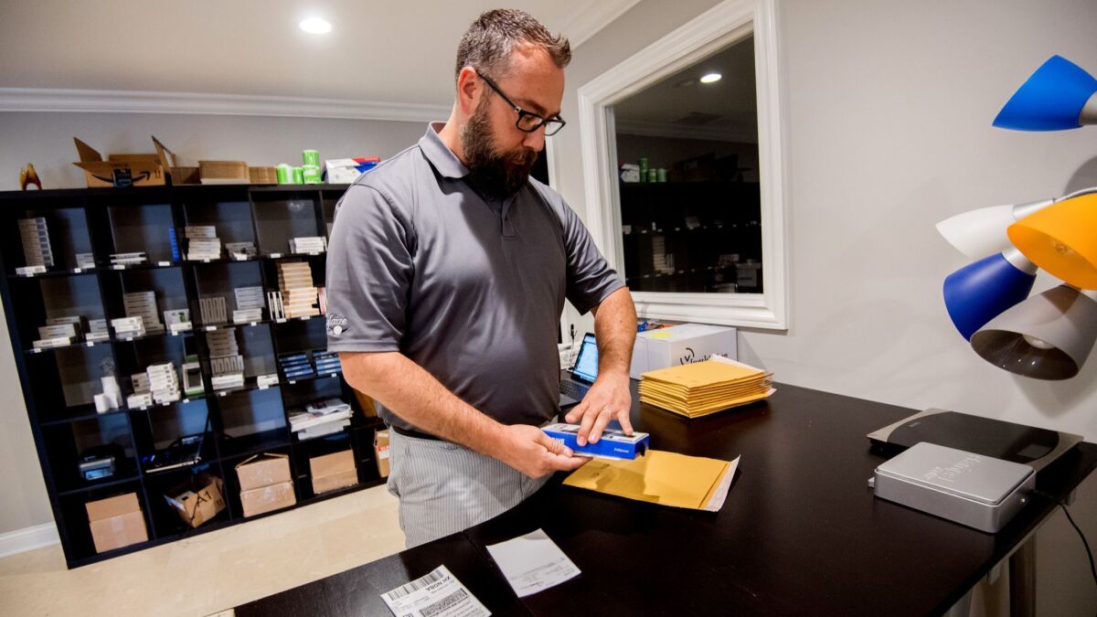 Dan Simpson packs an item for shipping at Fuse Chicken in Cuyahoga Falls, Ohio, in June.