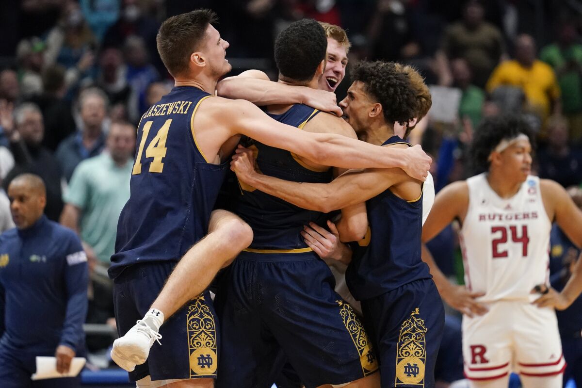 Notre Dame players celebrate after defeating Rutgers 89-87 in double overtime in a First Four game in the NCAA men's college basketball tournament, early Thursday, March 17, 2022, in Dayton, Ohio. (AP Photo/Jeff Dean)