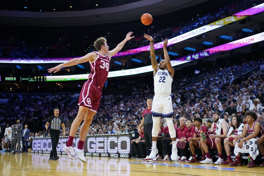 Villanova's Cam Whitmore, right, goes up for a shot against Oklahoma's Jacob Groves during the first half of an NCAA college basketball game, Saturday, Dec. 3, 2022, in Philadelphia. (AP Photo/Matt Slocum)
