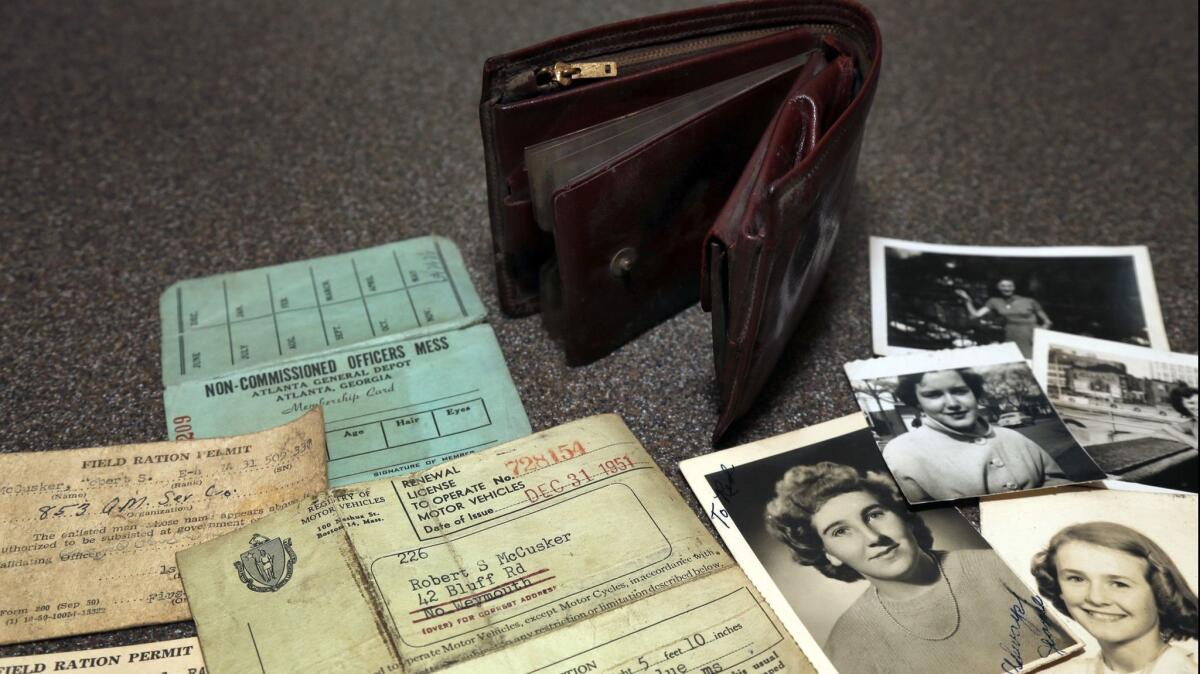 The lost wallet of Robert McCusker, a war veteran who served in World War II and Korea, is displayed with its contents on a kitchen table in Dover, N.H.