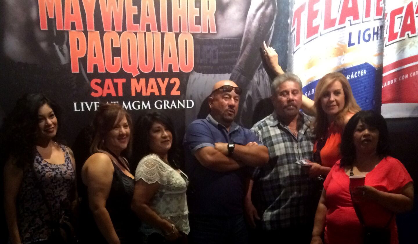 Boxing fans pose for a photo in front of a Mayweather-Pacquiao poster on Saturday in the lobby of the MGM Grand.
