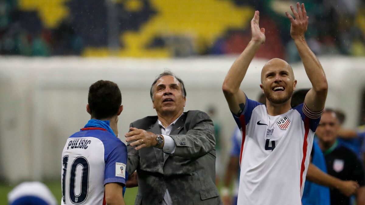 U.S. Coach Bruce Arena, center, celebrates with Christian Pulisic as Michael Bradley salutes supporters following a 1-1 tie with Mexico on June 11.