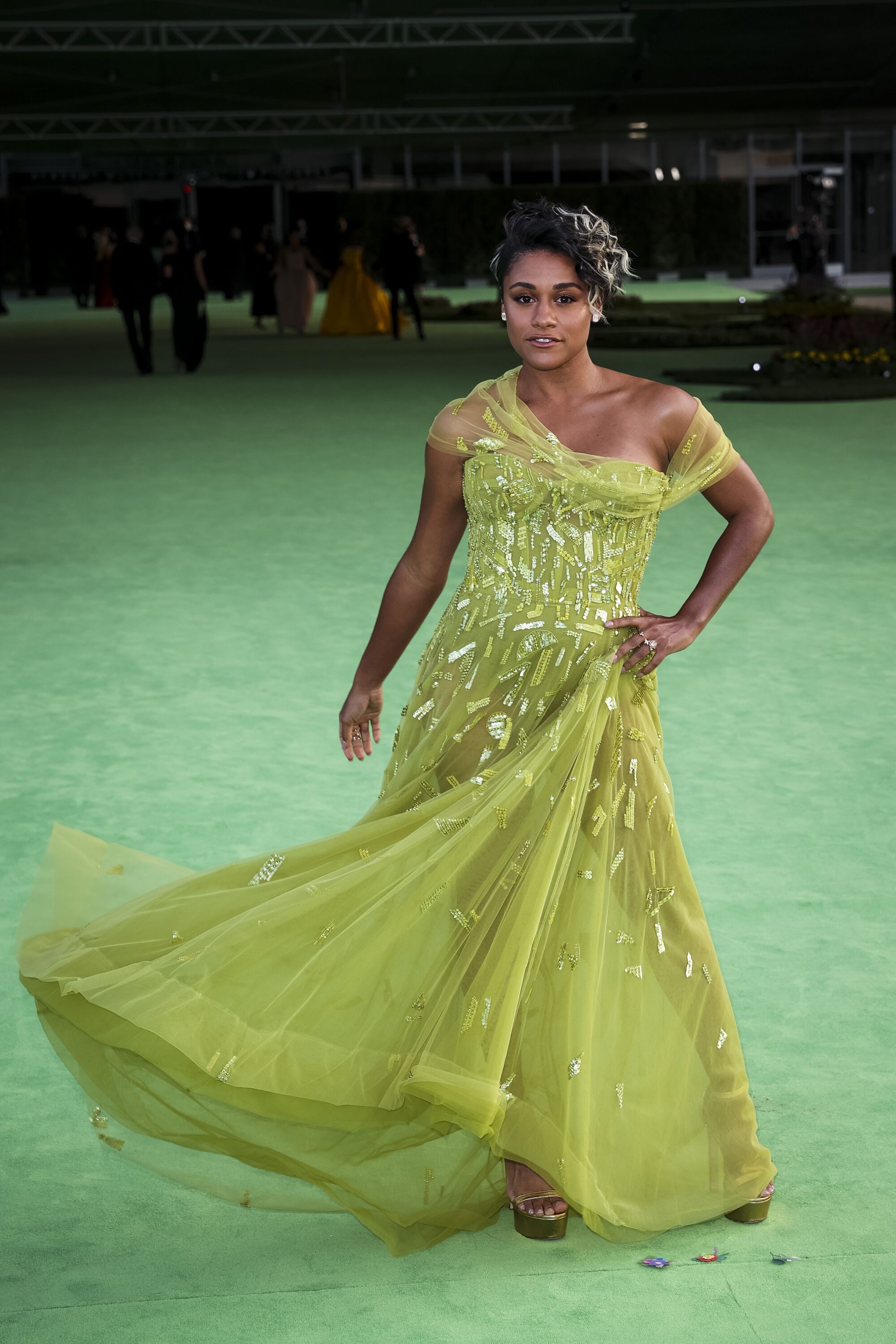 A woman in a green dress posing on a green carpet