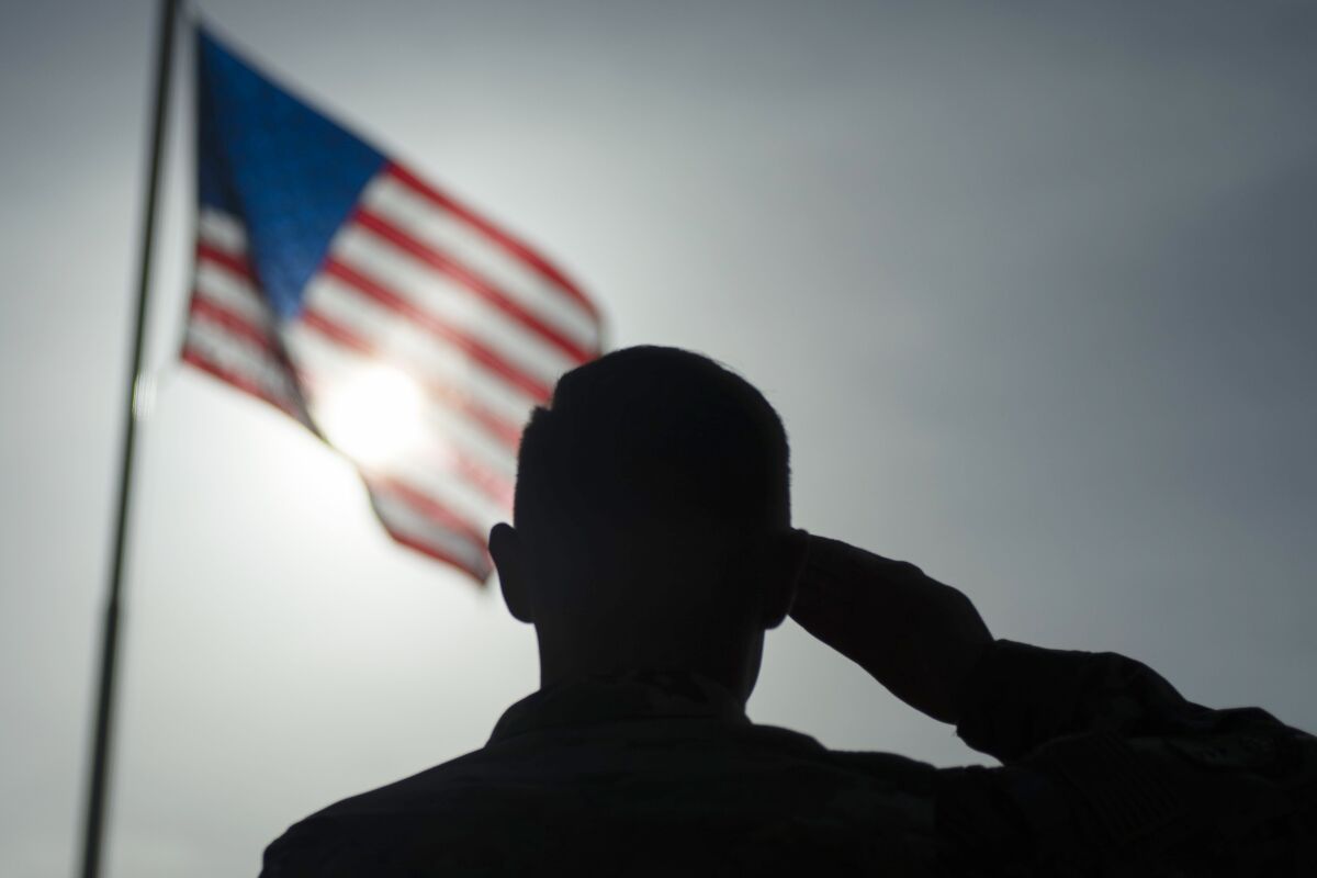 FILE - In this photo taken Aug. 26, 2019 and released by the U.S. Air Force, a U.S. Air Force Staff Sgt., salutes the flag during a ceremony signifying the change from tactical to enduring operations at Camp Simba, Manda Bay, Kenya. U.S. officials tell The Associated Press that military investigations have found that poor leadership, inadequate training and a "culture of complacency” among U.S. forces undermined efforts to fend off a 2020 attack by militants in Kenya that killed three Americans. (Staff Sgt. Lexie West/U.S. Air Force via AP, File )