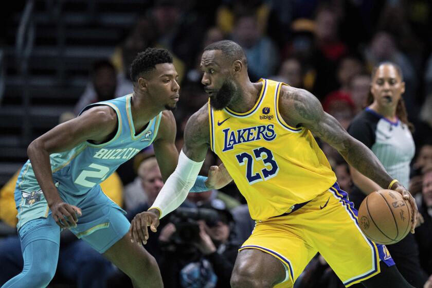 Los Angeles Lakers forward LeBron James (23) drives to the basket while guarded by Charlotte Hornets forward Brandon Miller (24) during the first half of an NBA basketball game Monday, Feb. 5, 2024, in Charlotte, N.C. (AP Photo/Jacob Kupferman)