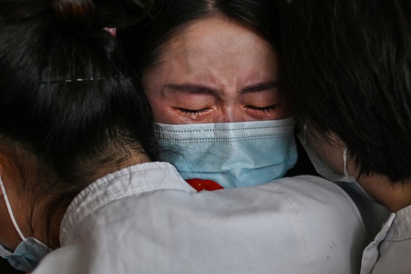 CHINA: Medical staff from Jilin Province (C) hug nurses from Wuhan after working together during the COVID-19 coronavirus outbreak during a ceremony before leaving as Tianhe Airport is reopened in Wuhan in China's central Hubei province on April 8, 2020.