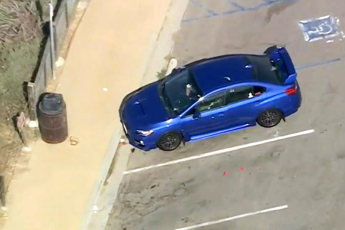 An aerial frame of a single car parked in a parking strip 