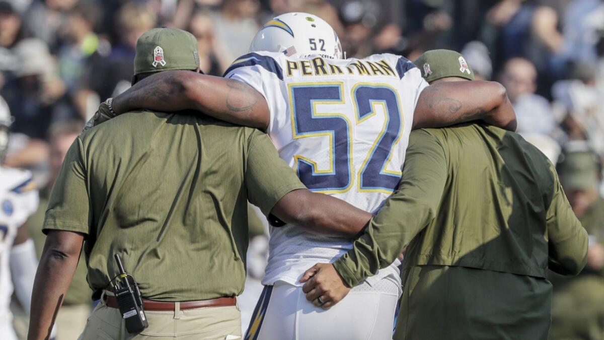 Chargers linebacker Denzel Perryman is helped off the field after sustaining an injury to his left knee against the Raiders at Oakland-Alameda County Coliseum on Nov. 11, 2018.