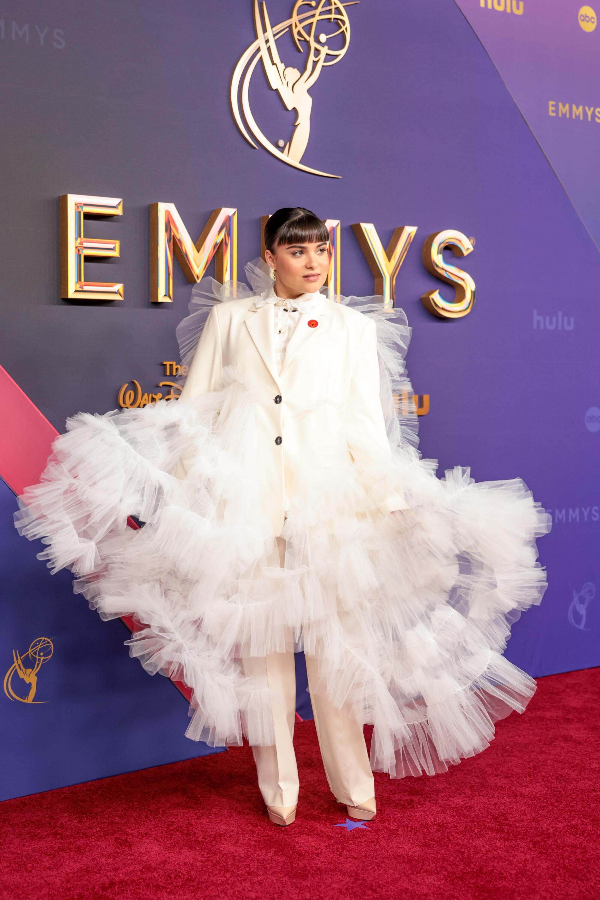 Devery Jacobs wears a suit with ruffles.