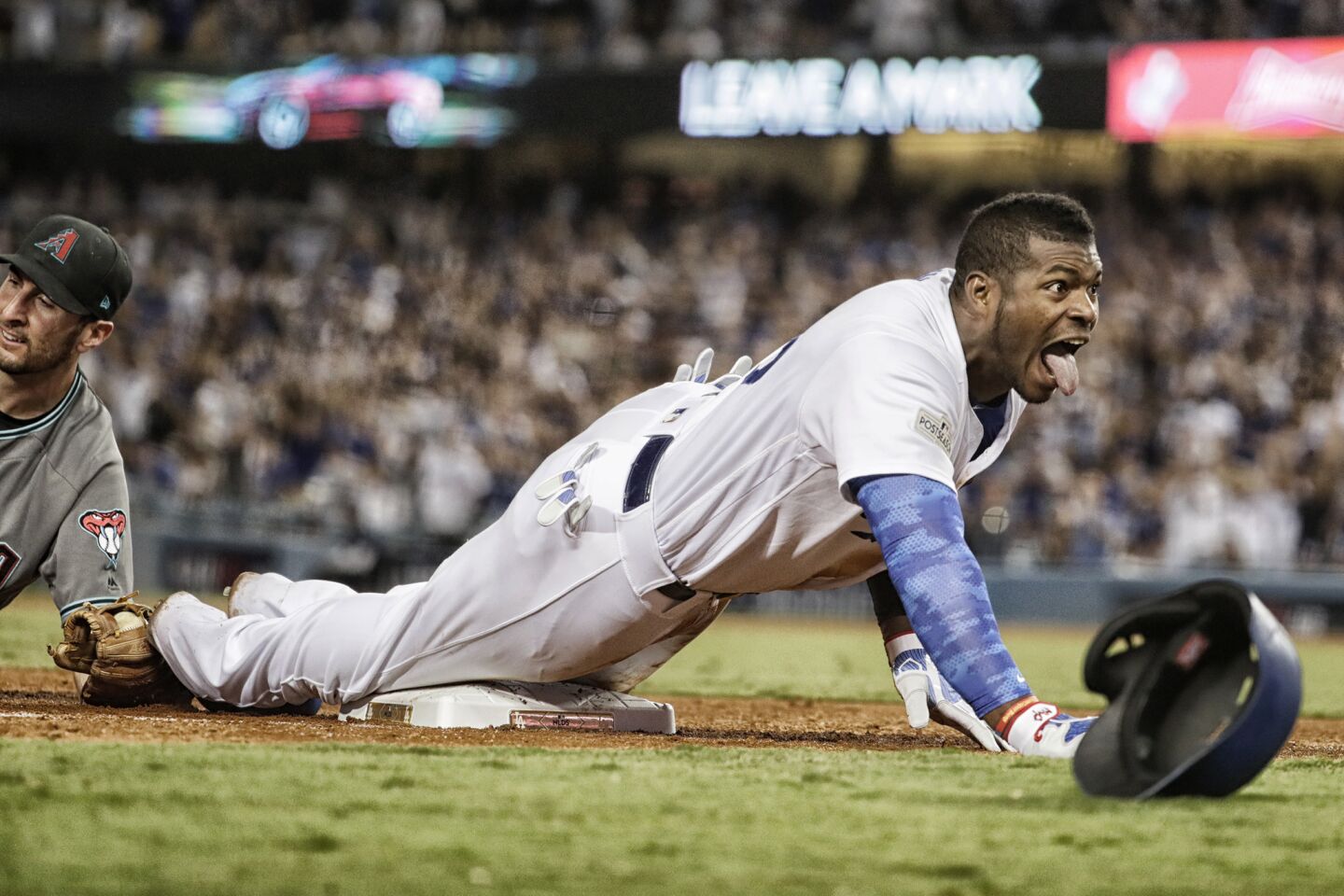 Dodgers right fielder Yasiel Puig gets wild after sliding into third base past the tage of Diamondbacks third baseman Adam Rosales for a seventh inning triple in Game 1 of the NLDS at Dodger Stadium.